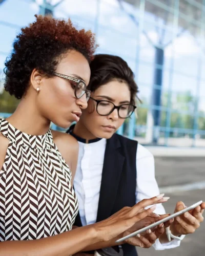 two-young-successful-businesswomen-looking-tablet-business-centre